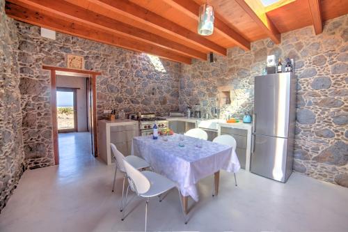 a kitchen with a table with chairs and a refrigerator at La Molina NK in Tindaya