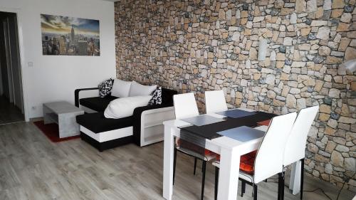 un soggiorno con un tavolo e un muro di pietra di Your2ndhome-3 a Sindelfingen