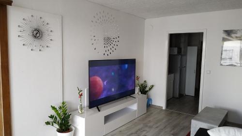 un soggiorno con TV a schermo piatto su una parete bianca di Your2ndhome-3 a Sindelfingen