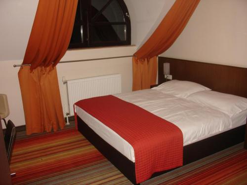 B&B Janežič في ليوبليانا: غرفة نوم بسرير كبير مع ستائر برتقالية