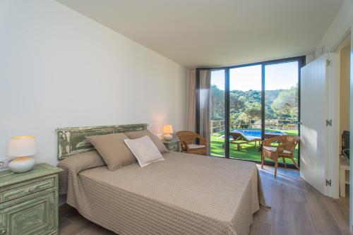 a bedroom with a bed and a view of a pool at Nou Sol Solet in Begur
