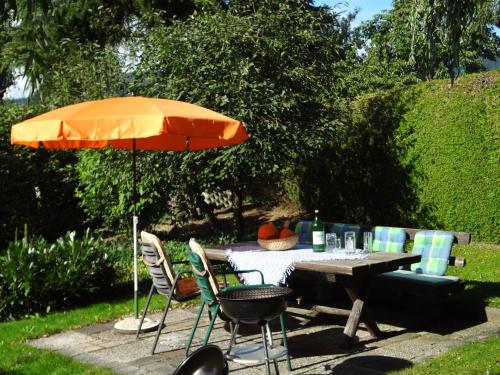 a table and chairs with an orange umbrella and a table and chairs sidx sidx sidx at Haus Christine Aigen Schlägl - Adalbert Stifter in Aigen im Mühlkreis