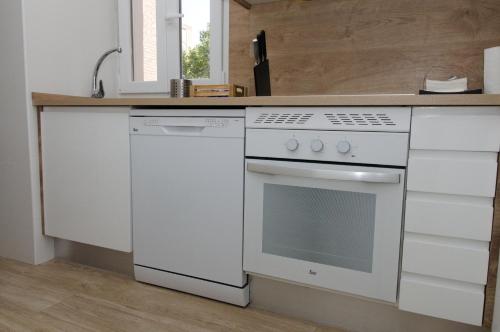 a kitchen with a white stove and a sink at Moderno,tranquilo, entrada autónoma y fácil aparcamiento. in Madrid