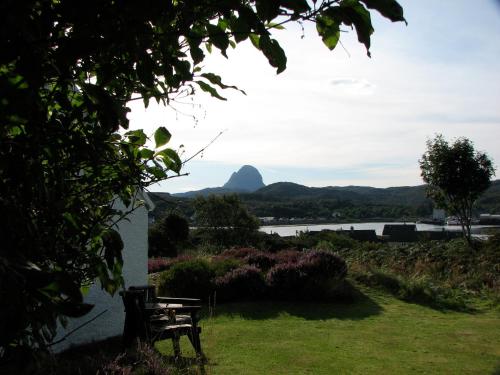 a picnic table with a view of a mountain at Tigh-na-Mara in Lochinver