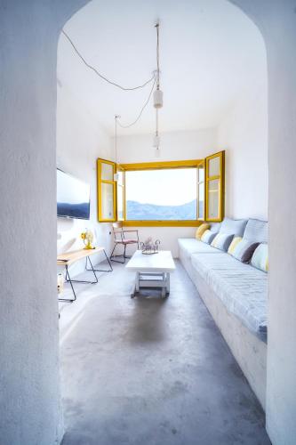 a living room with a large couch and a table at Serifos 1890 cliff house in Serifos Chora