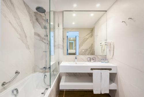 a white bathroom with a sink and a shower at Occidental Vigo in Vigo