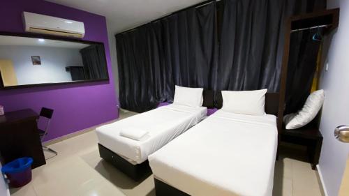 a hotel room with two beds and a mirror at SMART HOTEL SEKSYEN 15 SHAH ALAM in Shah Alam