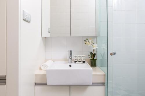 biała łazienka z umywalką i prysznicem w obiekcie Ravenscourt’s Studio Apartment Close to Everything w mieście Sydney