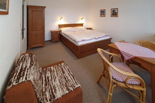a bedroom with a bed and a table and chairs at Selský dvůr 1 in Police nad Metují