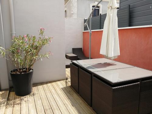 d'un balcon avec une table et une plante en pot. dans l'établissement Maison de vacances au cœur des Sables d’Olonne, à Les Sables-dʼOlonne