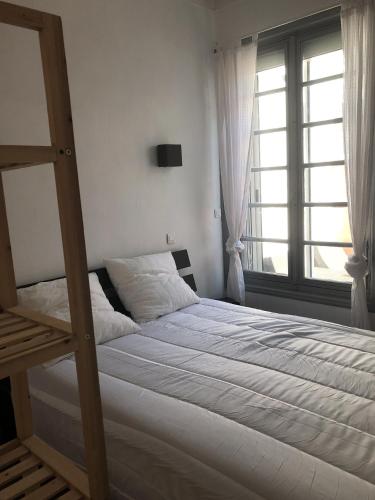 une chambre avec un lit superposé et une fenêtre dans l'établissement Maison de vacances au cœur des Sables d’Olonne, à Les Sables-dʼOlonne