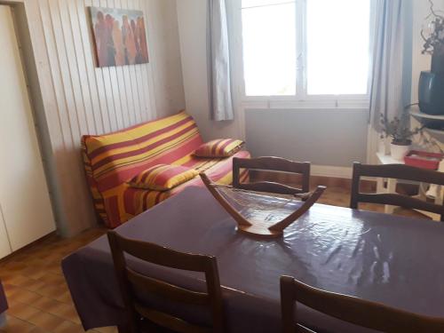 a living room with a table and a couch at Un petit coin de campagne dans le pays de Saint-Gilles in Saint-Maixent-sur-Vie