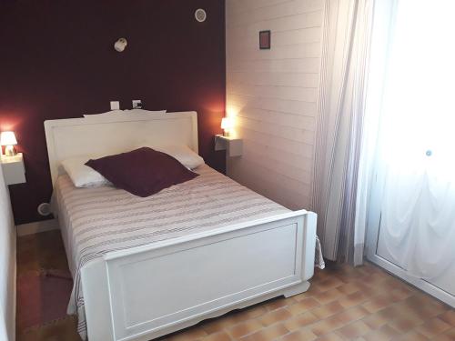 a bedroom with a white bed and a window at Un petit coin de campagne dans le pays de Saint-Gilles in Saint-Maixent-sur-Vie