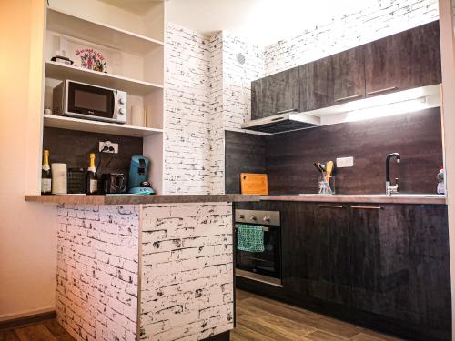 a kitchen with black and white brick walls at Léman Holidays - Le Blue Sky in Sciez