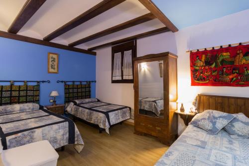 a bedroom with two beds and a painting on the wall at Casa Rural Senderismo in Lumbreras
