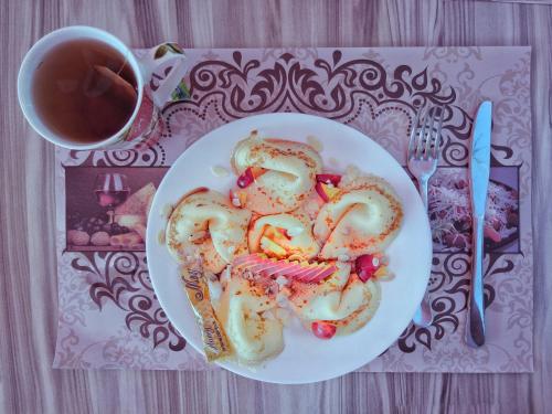 a plate of pretzels on a table with a cup of tea at Elizabeth Dy Boutique Hotel in Nesebar