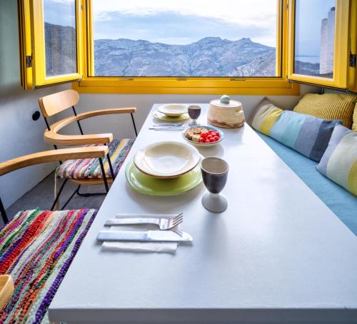 stół z talerzami i przyborami kuchennymi w pokoju w obiekcie Serifos 1890 cliff house w mieście Serifos Chora