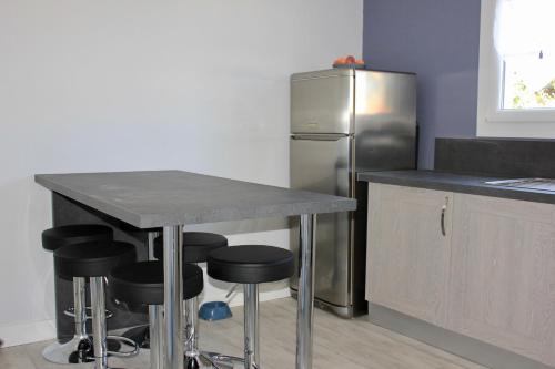 La cuisine est équipée d'un comptoir avec tabourets et d'un réfrigérateur. dans l'établissement Maison pour 6 au coeur de Saint-Hilaire-de-Riez, à Saint-Hilaire-de-Riez