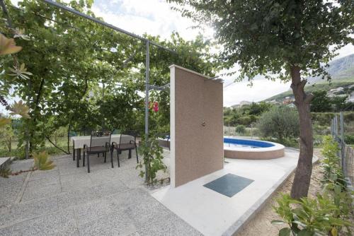 une terrasse avec une table et une piscine dans l'établissement Holiday home Elijah Creek, à Split