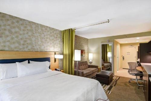 a hotel room with a bed and a living room at Home2 Suites By Hilton Columbus/West, OH in Columbus