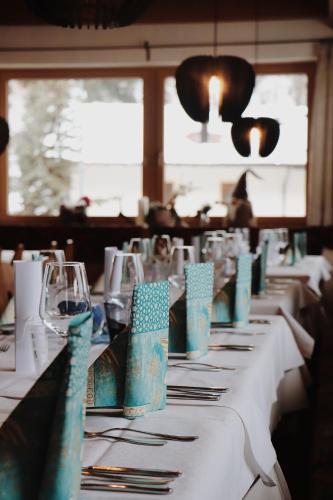 a long table with white table cloth and blue napkins at Hotel Martellerhof in Martello