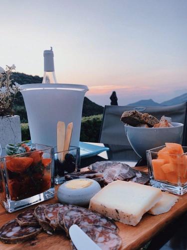 - une table en bois avec du fromage et d'autres aliments dans l'établissement Villa Milanu, à Oletta