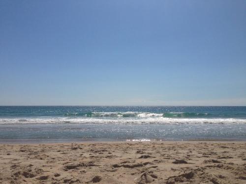 a sandy beach with waves in the ocean at Cape Hatteras Motel in Buxton