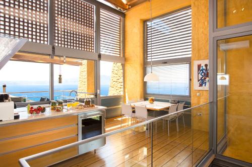 a kitchen and dining room with a view of the ocean at Athina Epavlis - Ethereal Charm of Blue Horizons in Ravdhoúkha