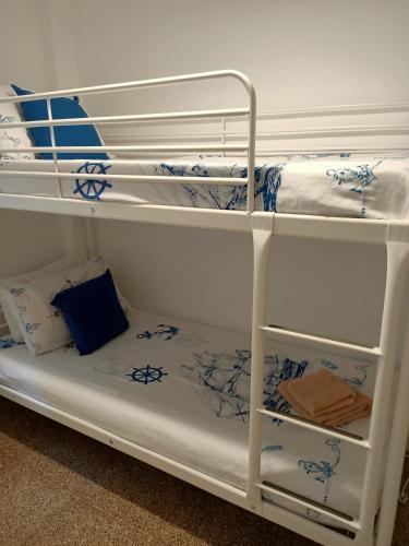 a white bunk bed with blue and white sheets at LA MAGIA DE PLAYA in Puerto de Sagunto