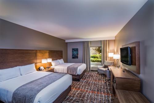 Habitación de hotel con 2 camas y TV de pantalla plana. en Choctaw Casino Hotel - Grant en Grant