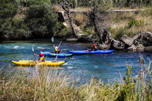 a group of people kayaking down a river at Hotel Castle Park in Berat