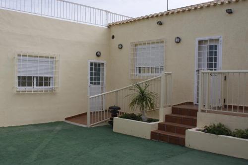 a building with stairs and windows and a courtyard at La Estancia del Rincon in Cabo de Palos