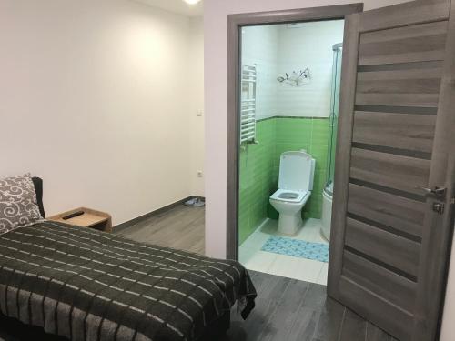 ラーヒフにあるZatishok Guest Houseのベッドルーム1室(ベッド1台付)、バスルーム(トイレ付)