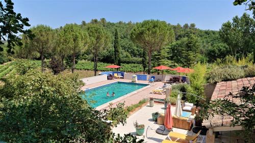 une piscine extérieure avec des chaises et des parasols dans l'établissement Une Campagne En Provence, à Bras