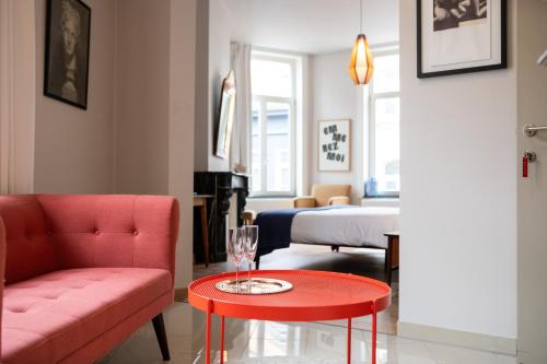 een woonkamer met een rode bank en een rode tafel bij B&B Belle de Nuit in Oostende