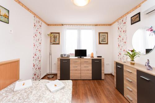 a bedroom with a bed and a dresser and a mirror at Tip-Top Apartman Ház in Szeged