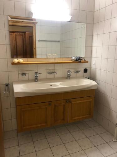 a bathroom with a sink and a mirror at Alpenhotel Widderstein in Mittelberg