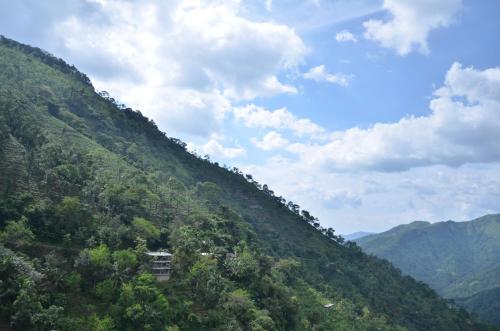 a view of a hill with a house on it at Spice Grove in Thekkady