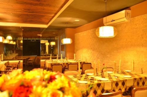 a dining room with tables and chairs and a screen at Spice Grove in Thekkady