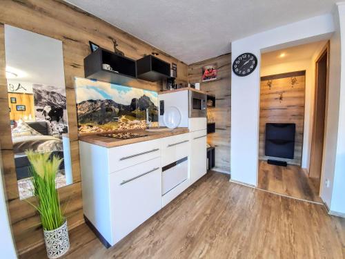 a kitchen with wooden walls and a white refrigerator at Ferienwohnungen Wolf - zentral in Pfronten mit Panorama-Alpenblick und ruhiger Lage in Pfronten