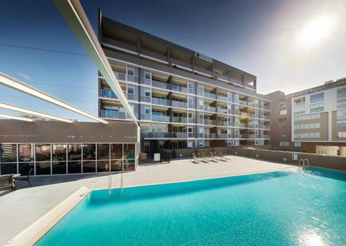 a swimming pool in front of a building at Honeysuckle Executive Apartments in Newcastle