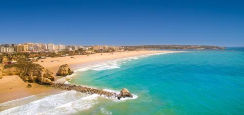 - une vue aérienne sur une plage avec des rochers dans l'océan dans l'établissement RR Hotel da Rocha, à Portimão