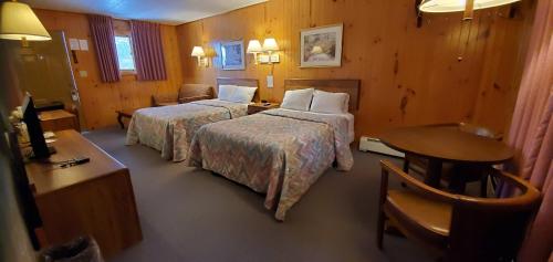 a hotel room with two beds and a table at Red Ranch Inn in Catskill