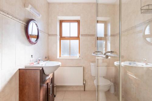 een badkamer met een wastafel, een toilet en een douche bij Álaind Lodges, Sneem in Sneem