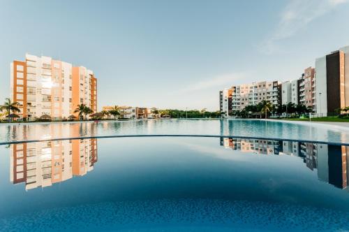una piscina de agua con edificios al fondo en Apartment in Cancun residential development, en Cancún