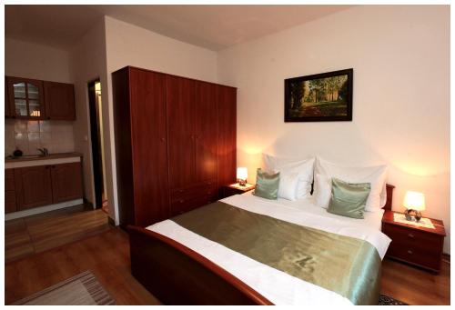 a bedroom with a large bed with green pillows at Restaurant penzion u Buchlovskeho zamku in Buchlovice