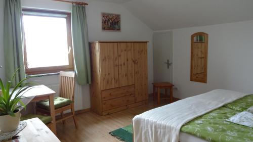 um quarto com uma cama, uma mesa e uma janela em Ferienwohnungen Klammsteiner em Lienz