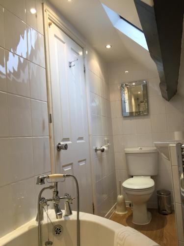 a bathroom with a toilet and a bath tub at Gatekeepers Lodge @ Plas Dinas in Caernarfon