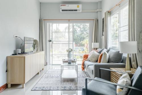 a living room with a couch and a table at Chiang Mai Jasmine Cottage in Chiang Mai