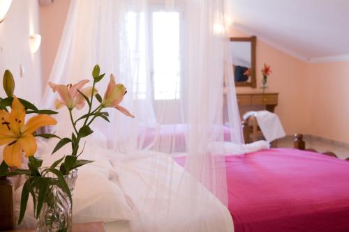 a bedroom with a pink bed with a window at Pansion Filoxenia Apartments & Studios in Tsoukaladhes